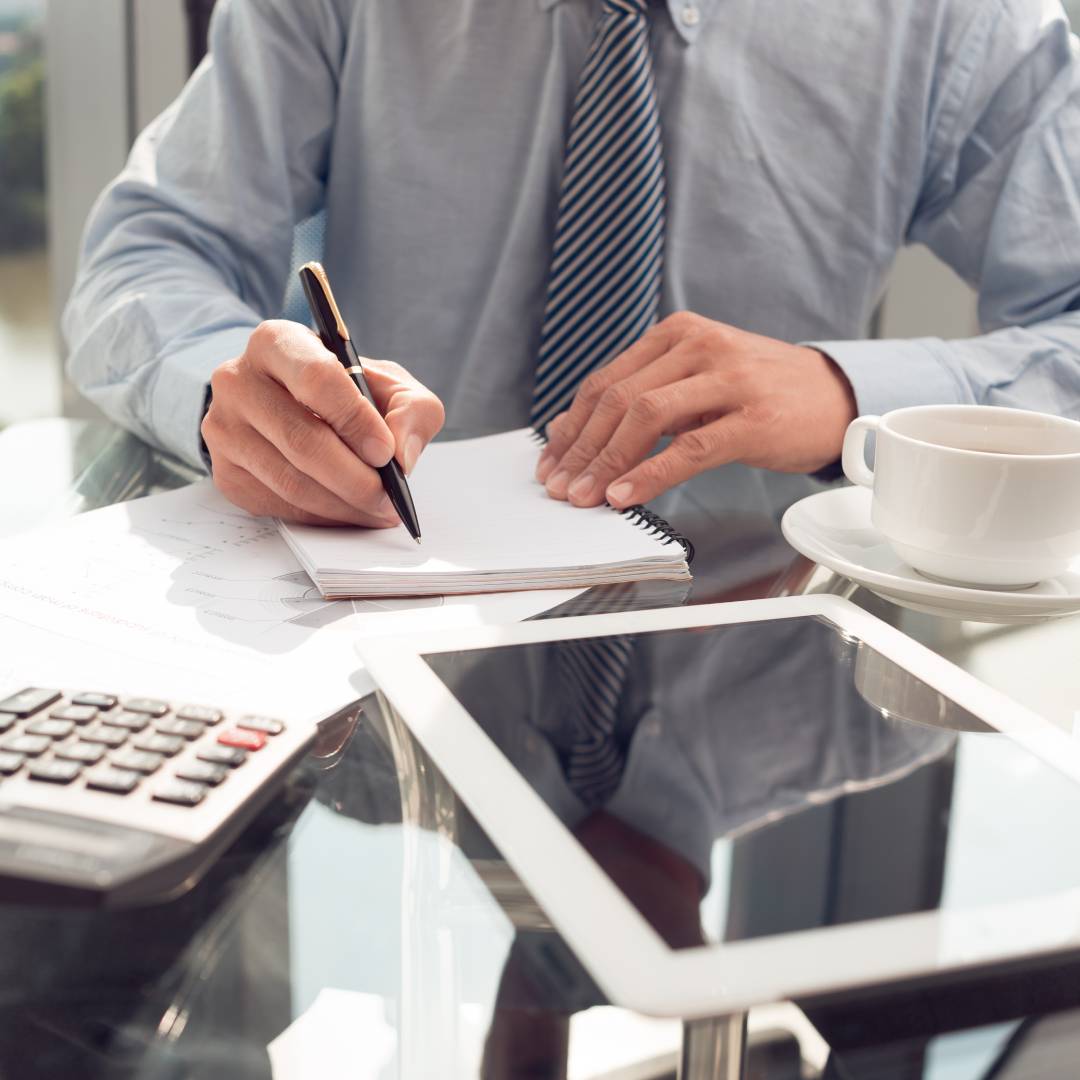 Person writing with pen on notebook